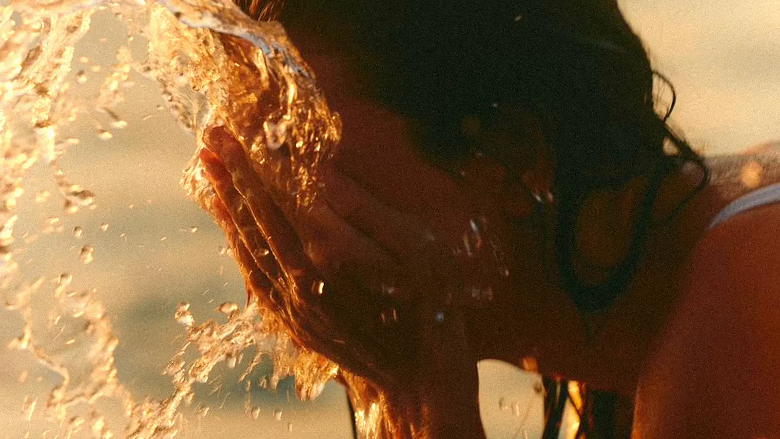 Golden water splashing in warm evening light